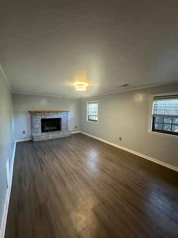 a view of empty room with wooden floor and fireplace