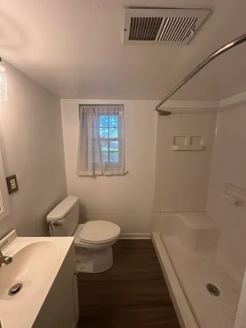 a bathroom with a sink a toilet and shower