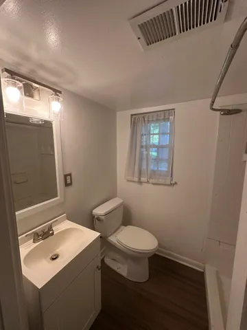 a bathroom with a toilet sink and mirror