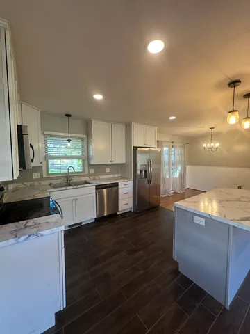 a kitchen with stainless steel appliances granite countertop a sink counter space and cabinets