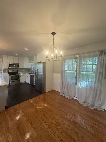 a view of a kitchen with wooden floor and a kitchen