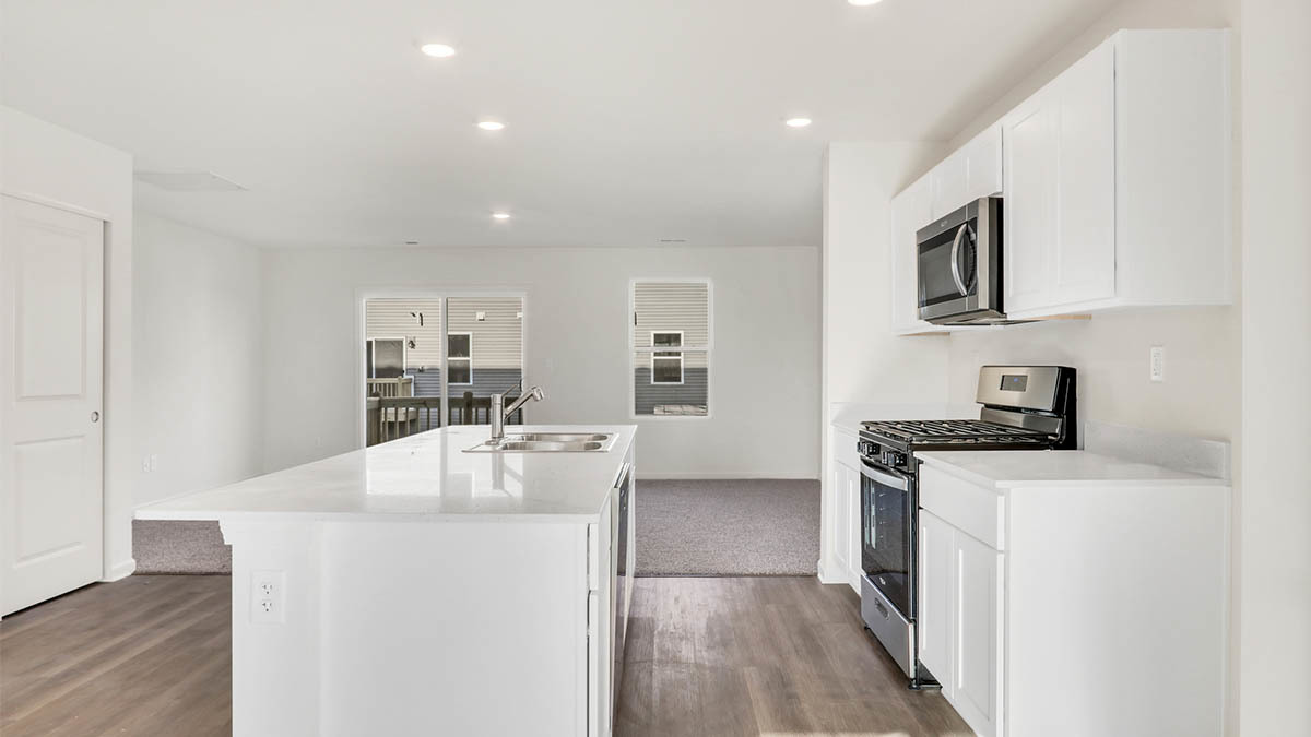 6510 Linden Trail, Unit C Wonder Lake, IL 60097 - Photo 4 of 24 a kitchen with stainless steel appliances a stove top oven a sink a refrigerator white cabinets and wooden floor