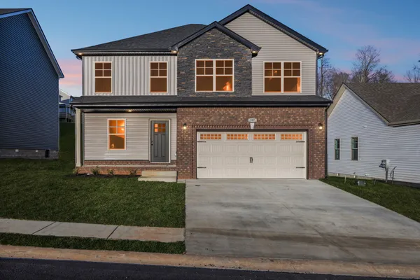 a front view of a house with a yard and garage