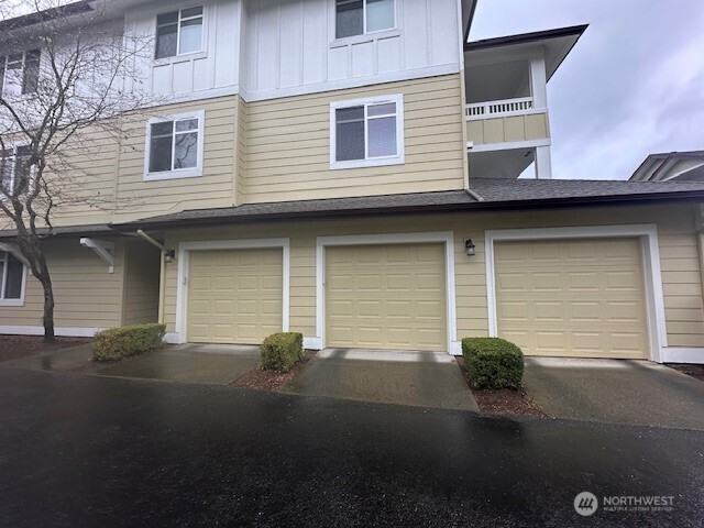 23943 Northeast 115th Lane, Unit 204 Redmond, WA 98053 - Photo 23 of 24 a front view of a house with a yard and garage