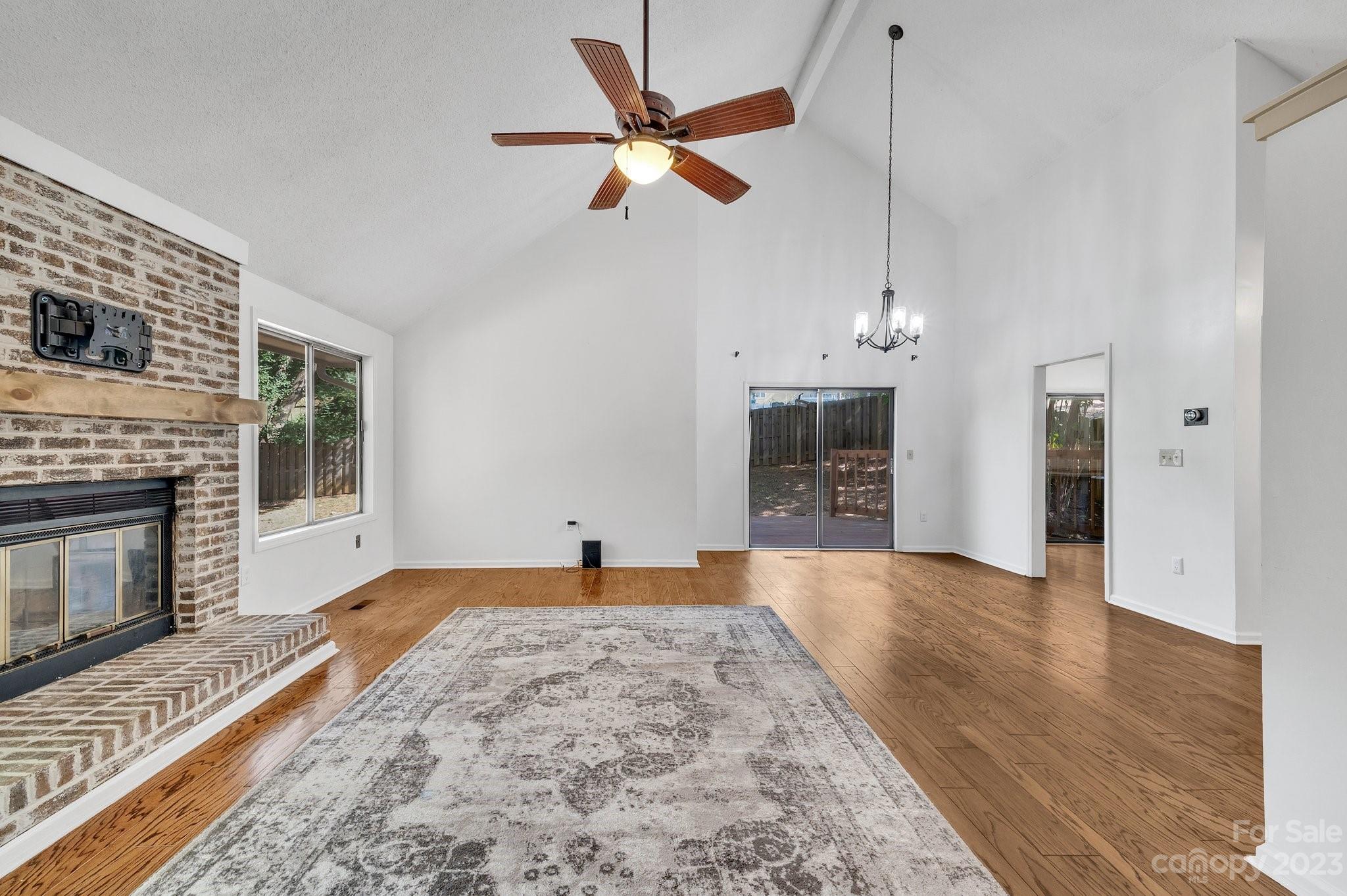 1016 Palmyra Drive Tega Cay, SC 29708 - Photo 8 of 33 a view of a livingroom with a fireplace a ceiling fan and windows