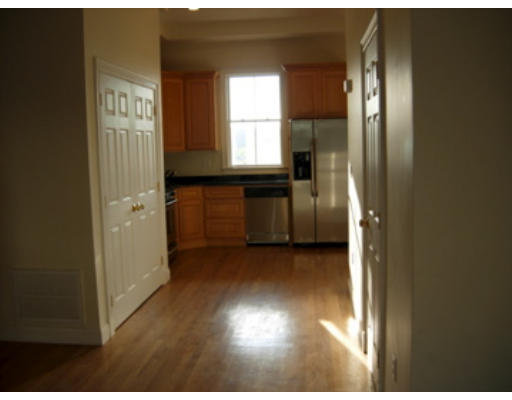 a view of a hallway with wooden floor and windows