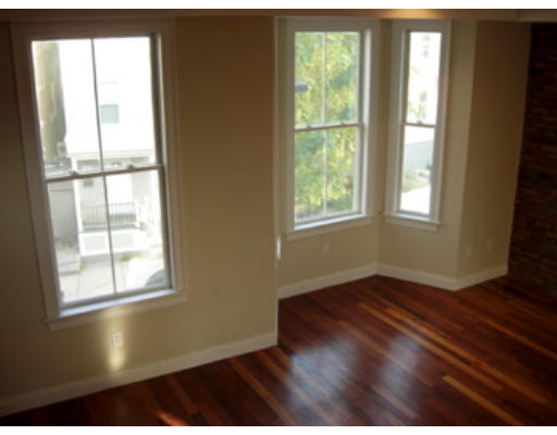 134 Marcella Street, Unit 2 Boston, MA 02119 - Photo 5 of 12 an empty room with wooden floor and windows