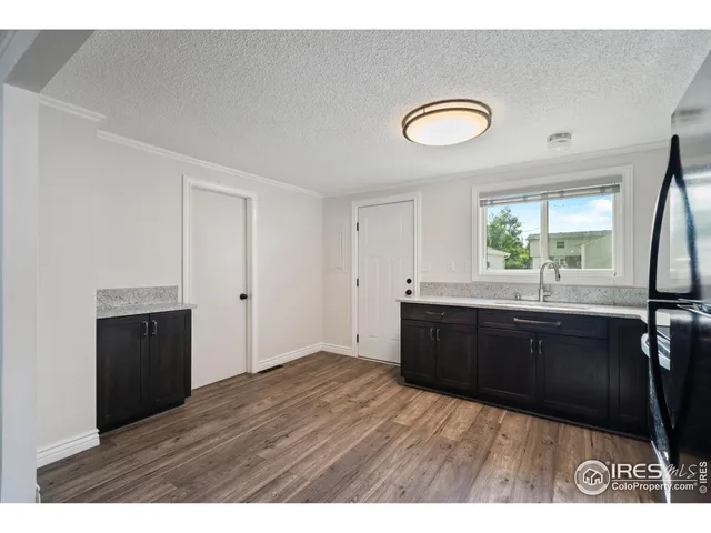 a kitchen with a refrigerator sink and wooden cabinets