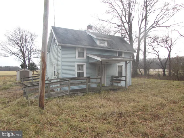 a view of a house with a yard and large tree