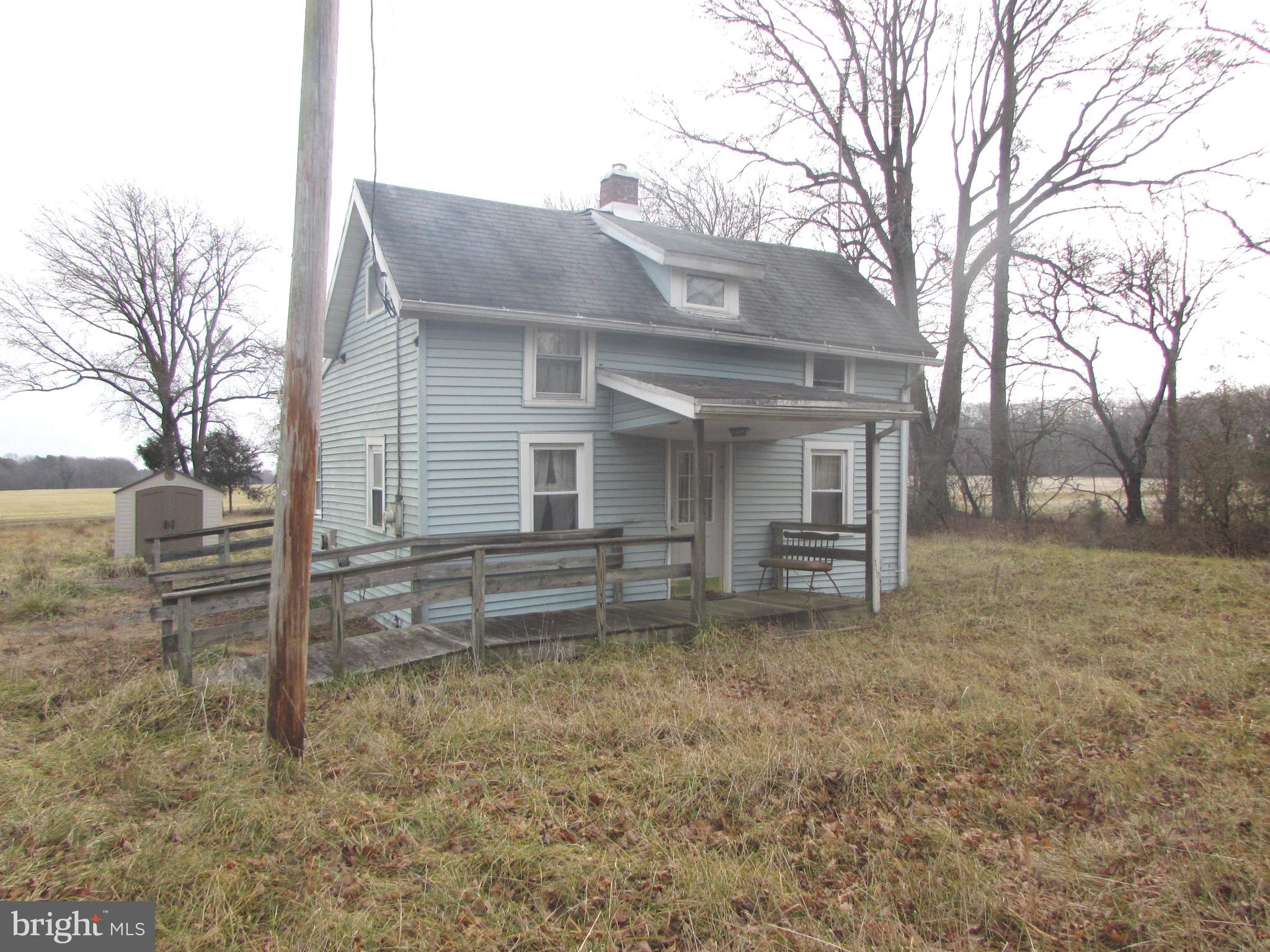 a view of a house with a yard and large tree