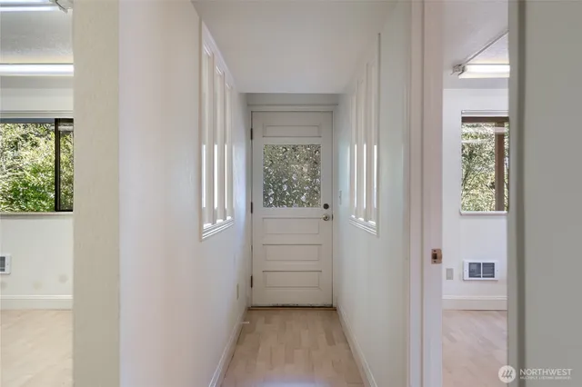 a view of a hallway with a window and a door