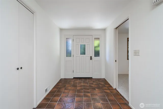 a view of a hallway with wooden floor and a bathroom