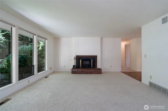 a view of an empty room with a fireplace and a window
