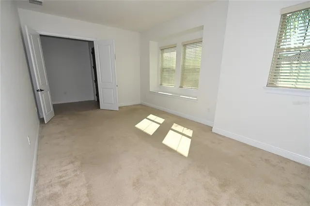 an empty room with windows and chandelier