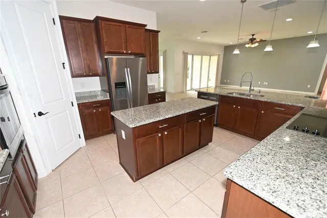 a kitchen with granite countertop a sink a stove and a refrigerator