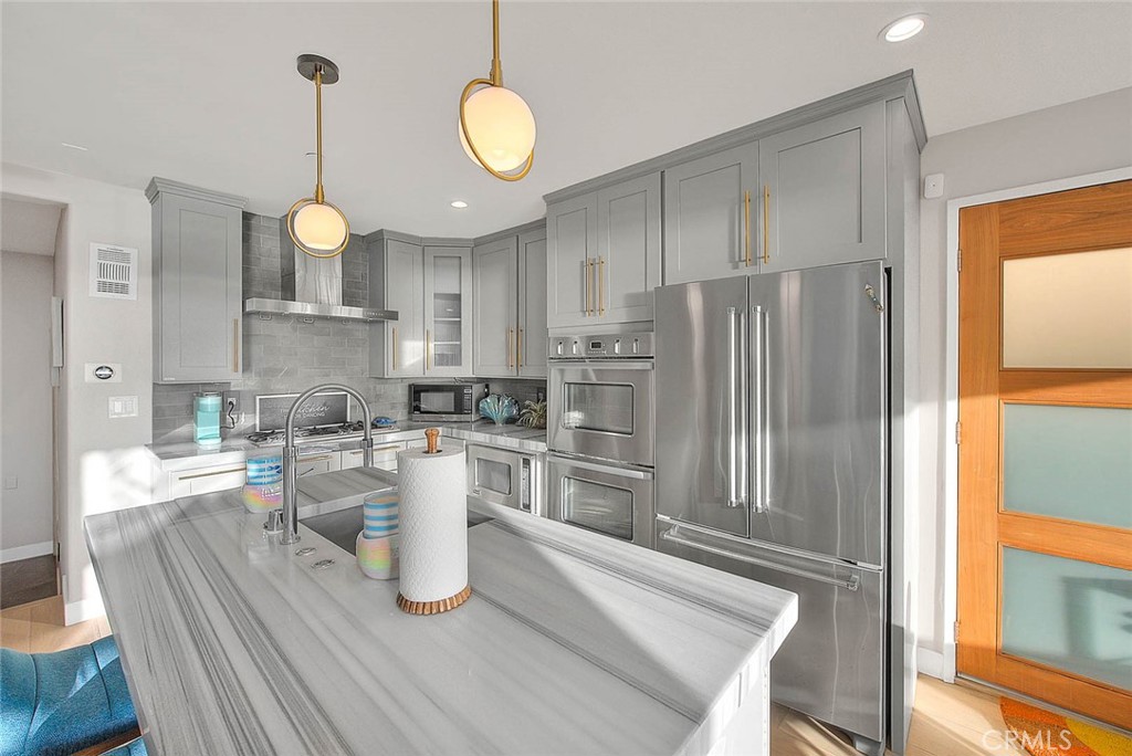 99 A Surfside Avenue Surfside, CA 90743 - Photo 6 of 75 a kitchen with sink a refrigerator and wooden floor