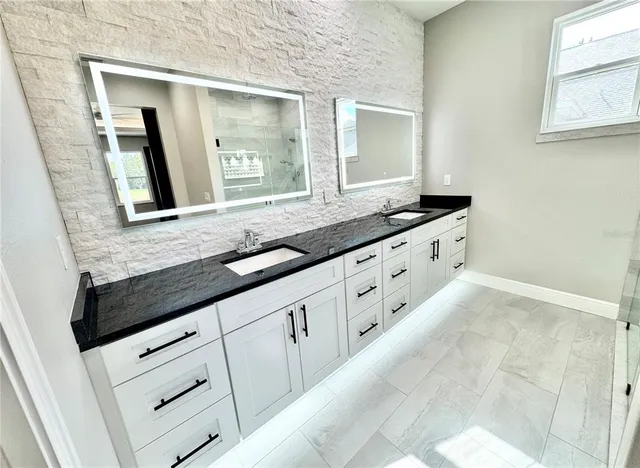 a bathroom with a granite countertop sink and mirror