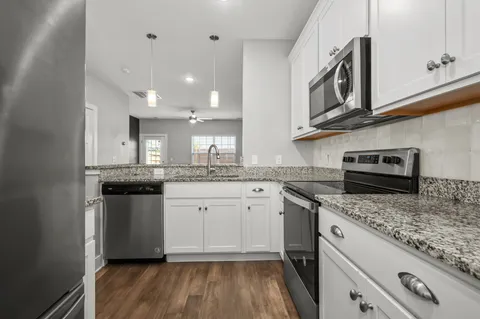 a kitchen with stainless steel appliances granite countertop hardwood a stove and cabinets