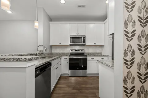 a kitchen with stainless steel appliances granite countertop a stove microwave and refrigerator