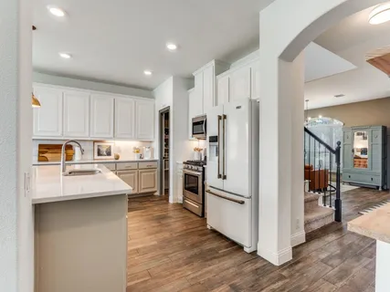a kitchen with white cabinets and stainless steel appliances