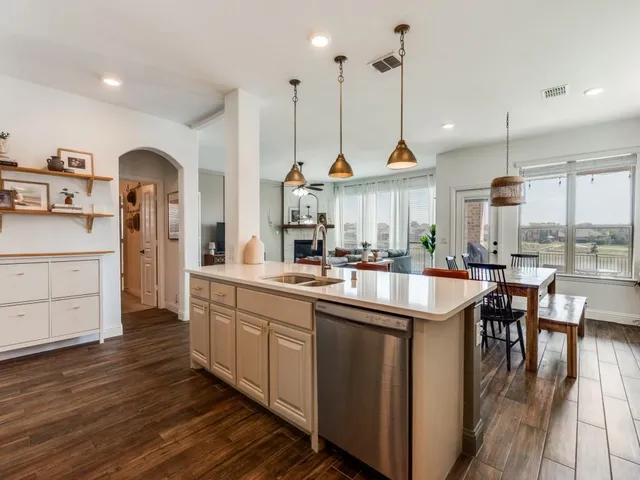 a view of a kitchen with refrigerator and wooden floor