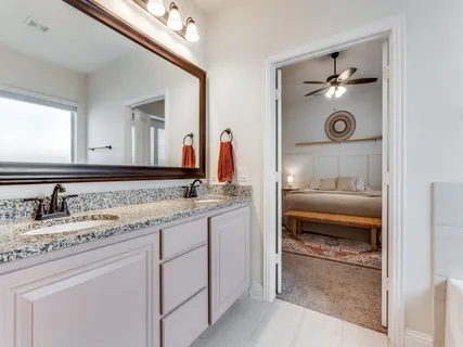a bathroom with a granite countertop sink and a mirror