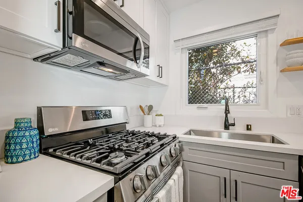 a kitchen with a stove a sink and a window