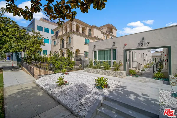 a front view of a house with a garden and patio