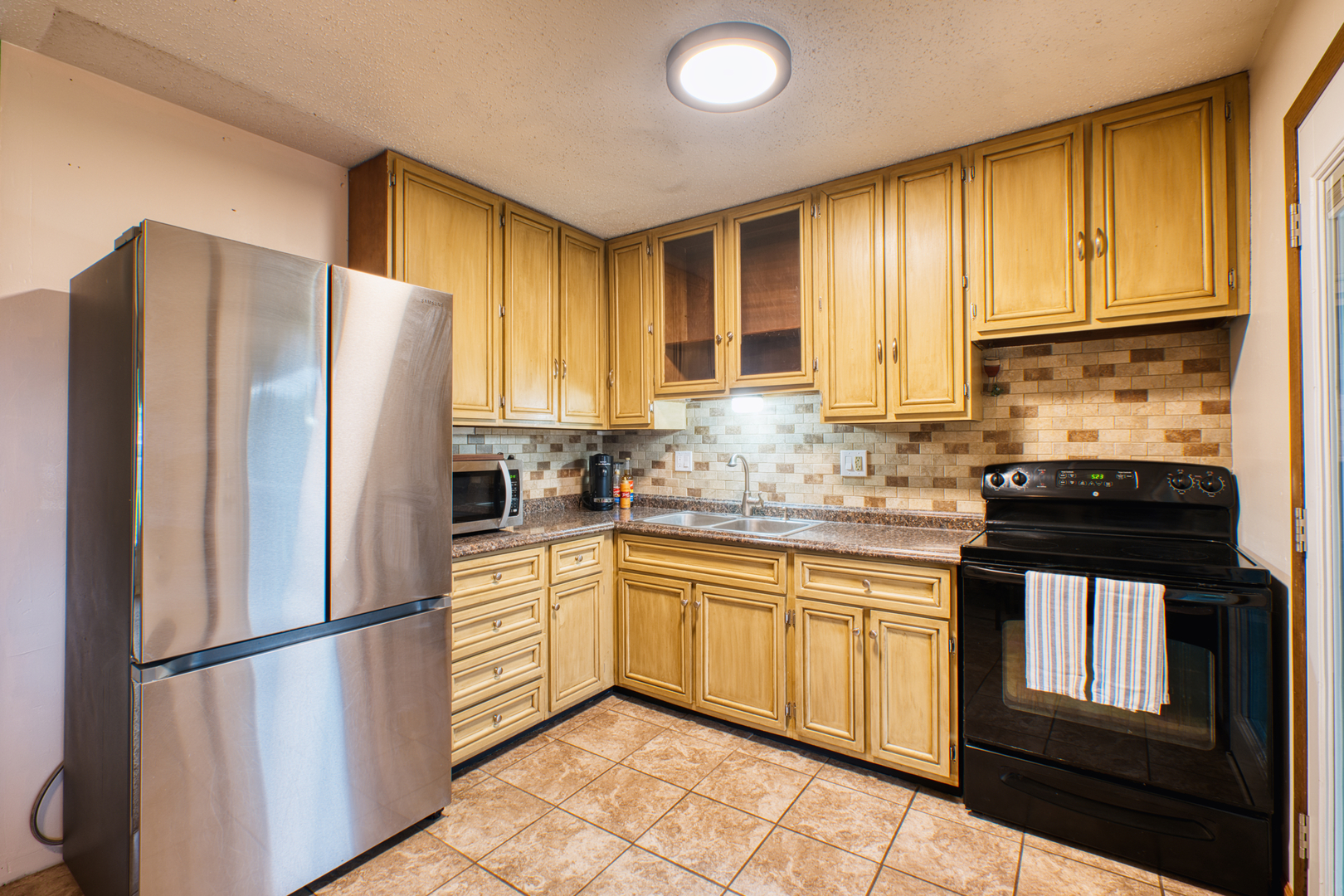2313 Lafayette Terrace Clinton, IA 52732 - Photo 8 of 39 a kitchen with stainless steel appliances granite countertop a refrigerator sink and cabinets