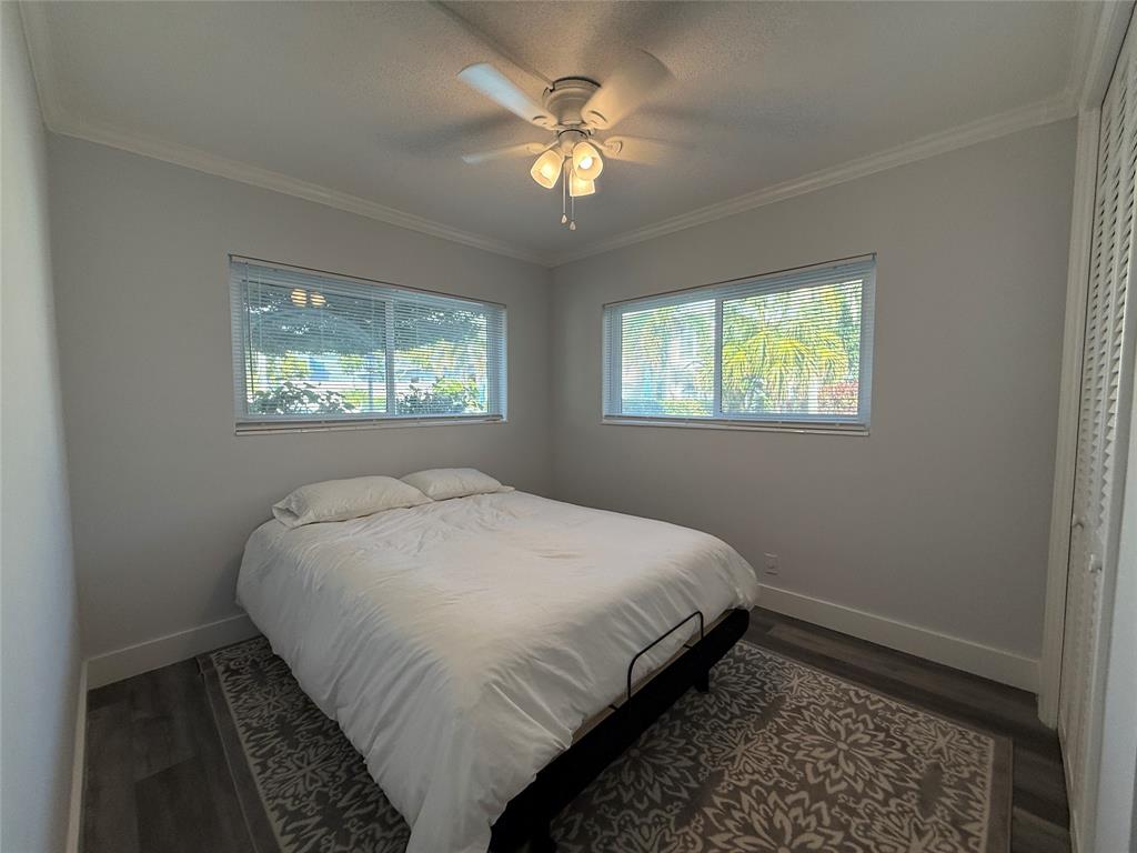2121 Northeast 42nd Court, Unit 103C Lighthouse Point, FL 33064 - Photo 17 of 31 a bedroom with a bed and a chandelier