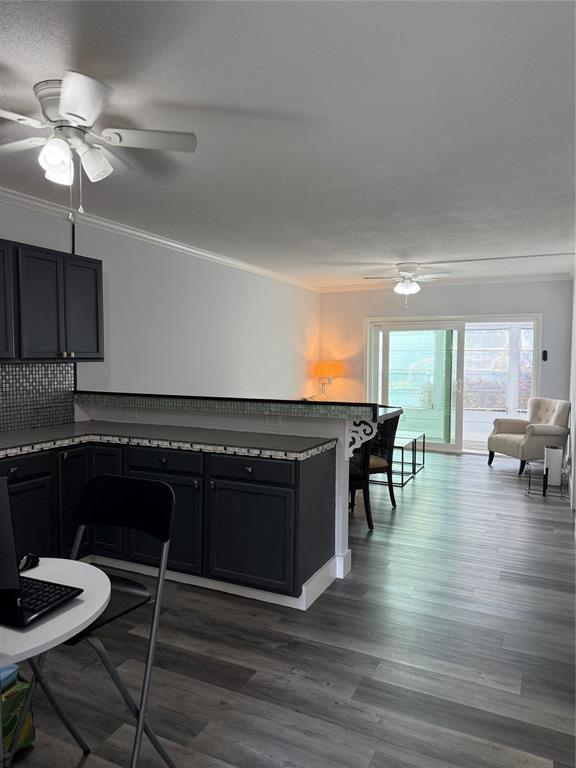 2121 Northeast 42nd Court, Unit 103C Lighthouse Point, FL 33064 - Photo 7 of 31 a kitchen with granite countertop a stove a sink a dining table and chairs with wooden floor
