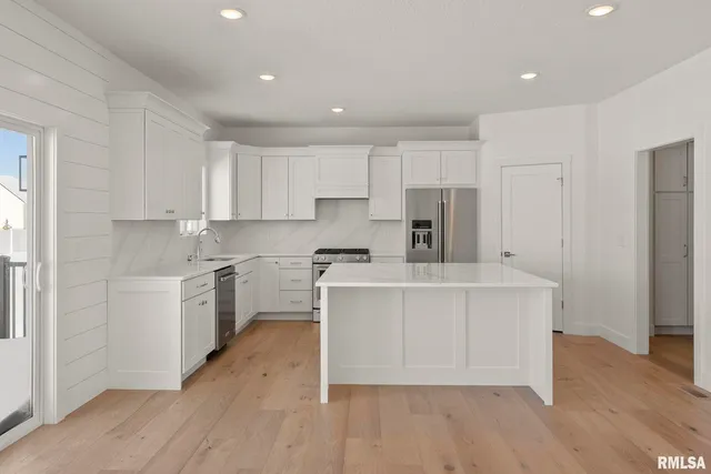 a kitchen with white cabinets stainless steel appliances and a sink