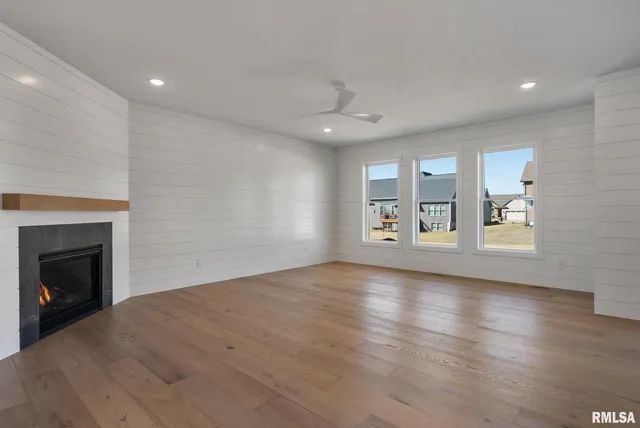 an empty room with windows and fireplace