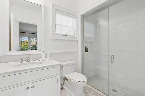 a bathroom with a sink toilet vanity and shower