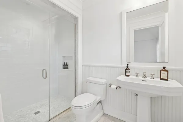 a bathroom with a toilet sink vanity and shower
