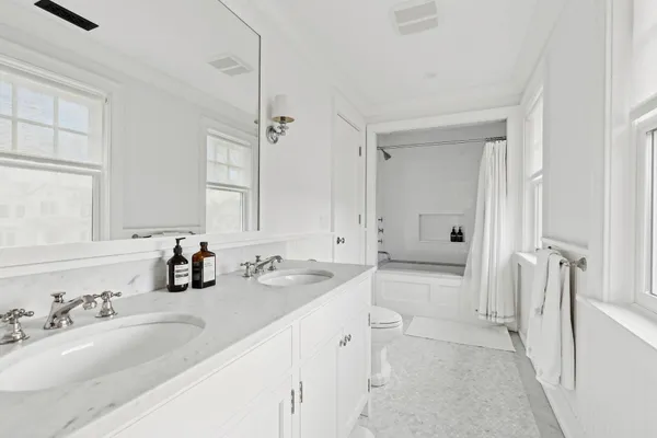 a bathroom with double vanity sinks and a bathtub