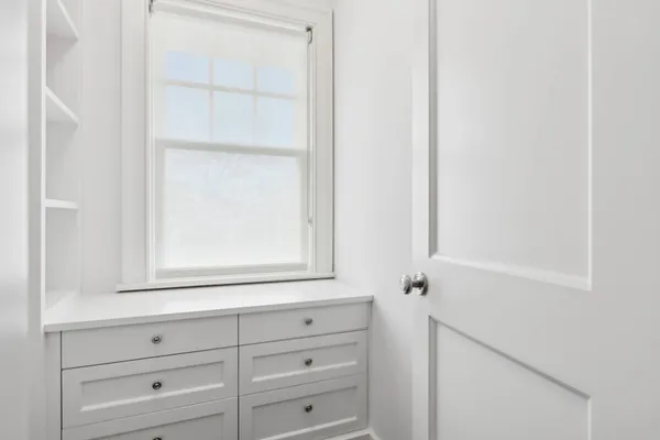 a view of white cabinets and a window
