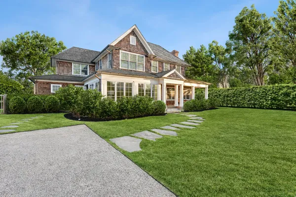 a front view of a house with a yard and potted plants