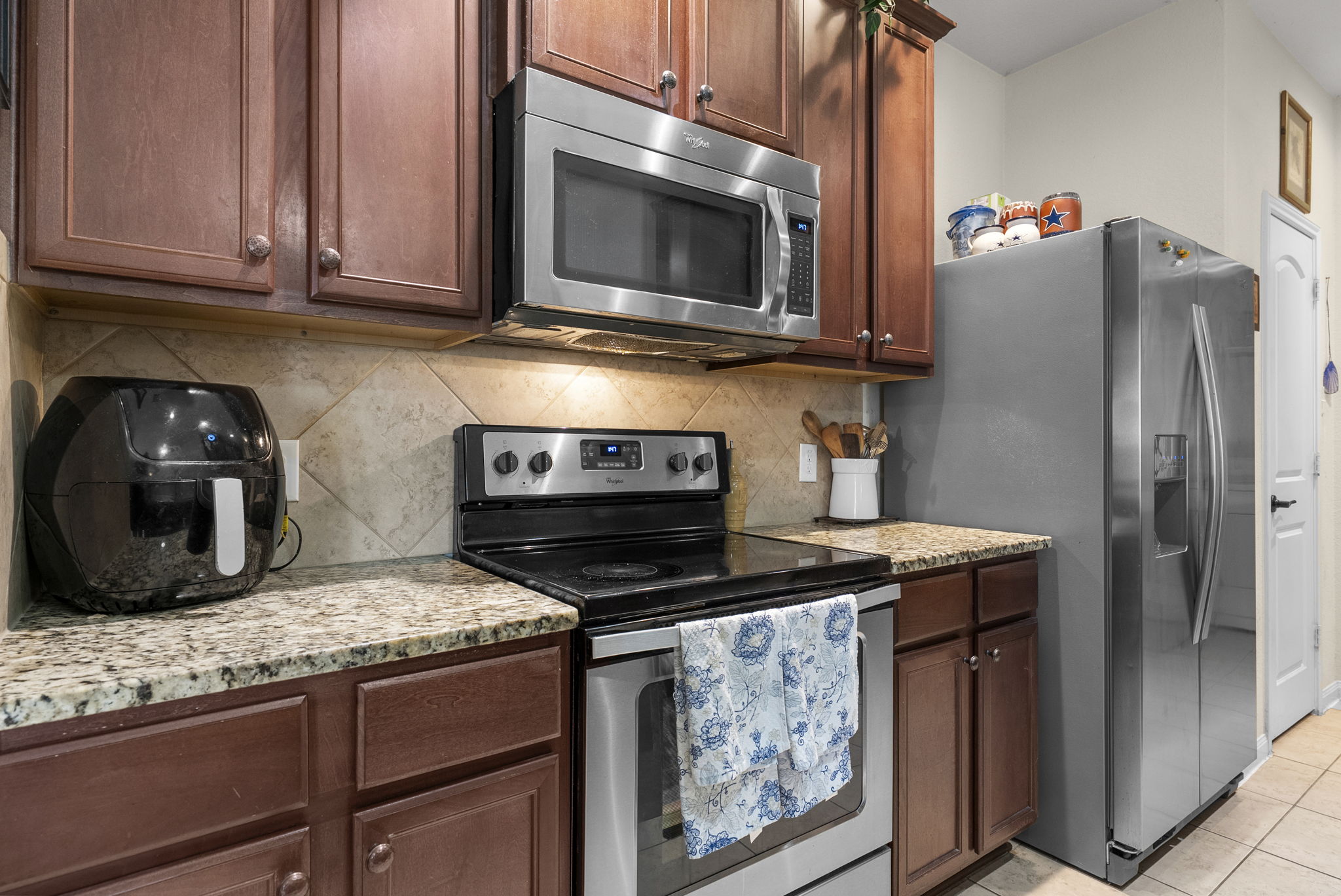 1617 Treeta Trail Kyle, TX 78640 - Photo 3 of 39 a kitchen with stainless steel appliances granite countertop a stove microwave and refrigerator