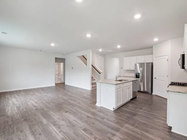 a kitchen with furniture and a wooden floor