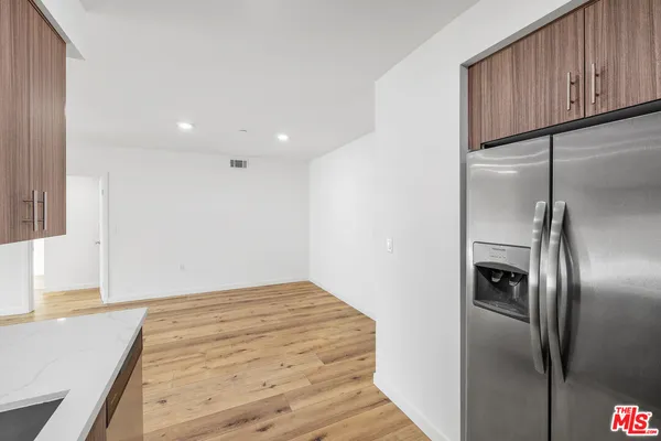 a view of a refrigerator in kitchen and wooden floor