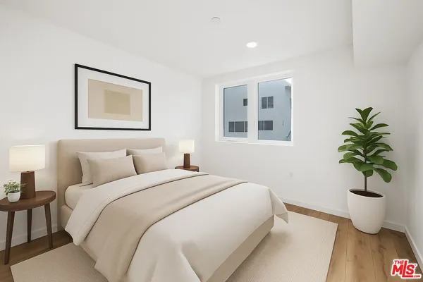 a bedroom with a bed and a potted plant