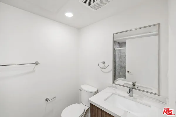 a bathroom with a sink a toilet and a mirror