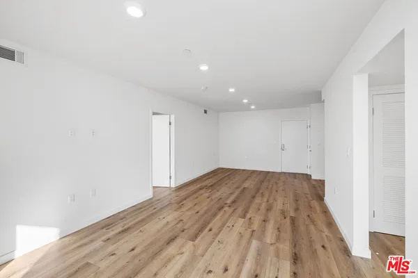 a view of empty room with wooden floor