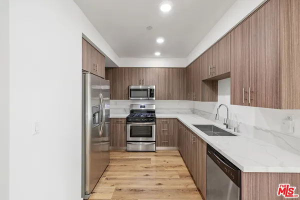 a kitchen with kitchen island granite countertop a sink stove and refrigerator
