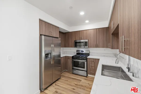 a kitchen with stainless steel appliances granite countertop a refrigerator stove and sink