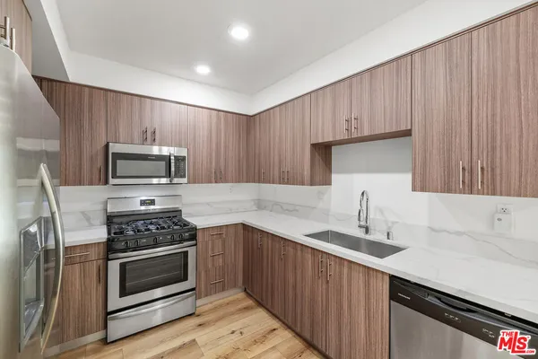 a kitchen with appliances a sink and a counter top space
