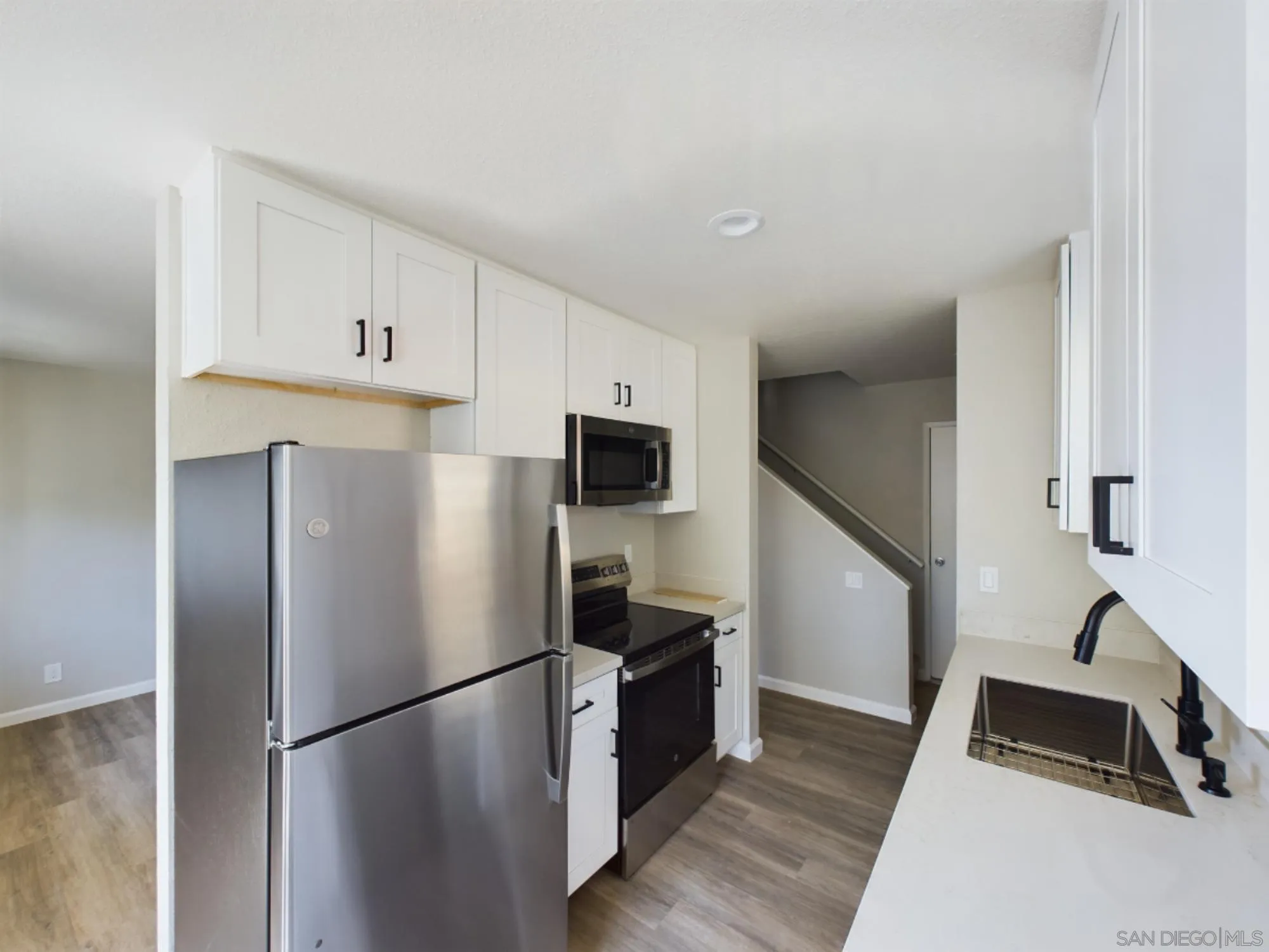 185 Saxony Road Encinitas, CA 92024 - Photo 11 of 14 a kitchen with a refrigerator a stove top oven and a refrigerator