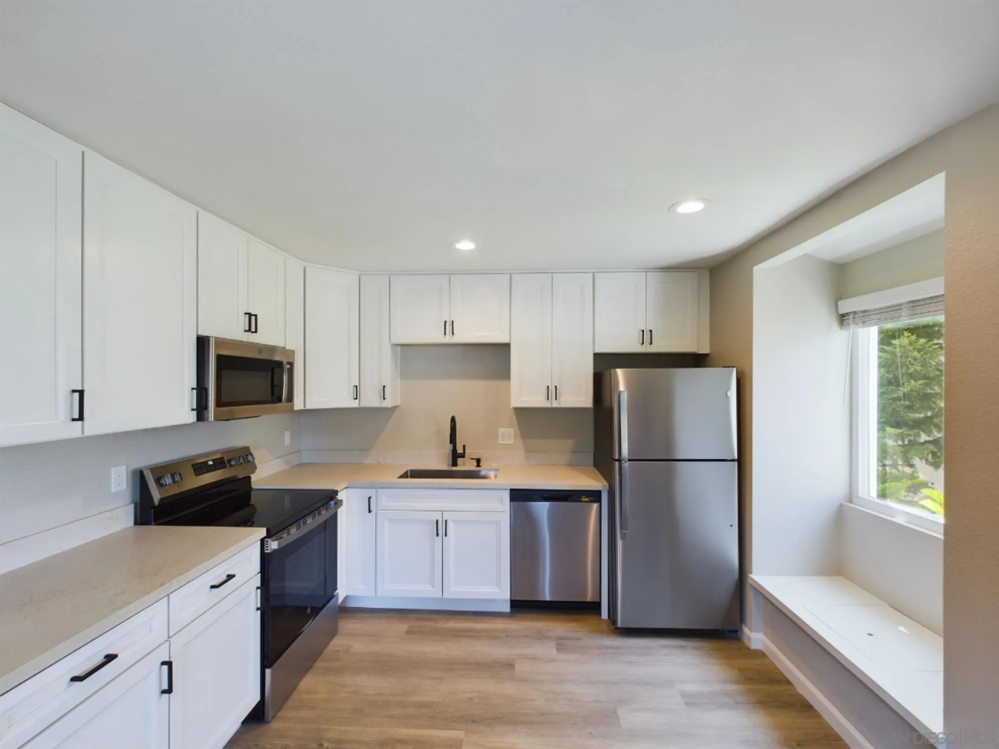 185 Saxony Road Encinitas, CA 92024 - Photo 13 of 14 a kitchen with stainless steel appliances and a refrigerator