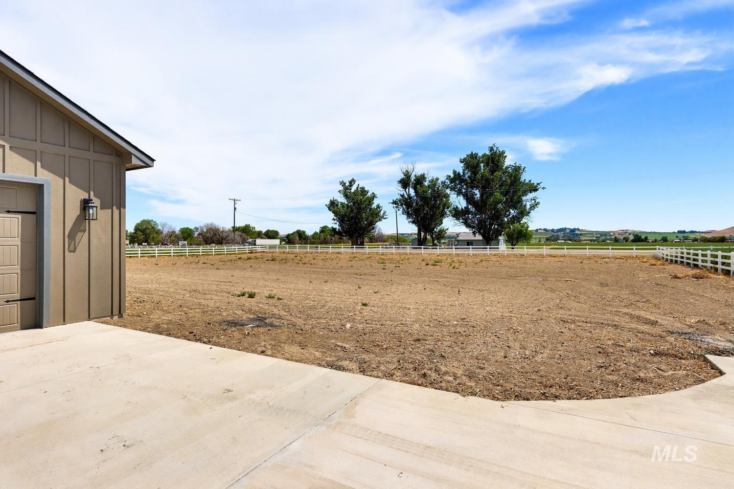 5054 Heritage Drive Marsing, ID 83639 - Photo 35 of 38 Expansive cleared lot with perimeter fencing, featuring a concrete driveway and an exterior wall with vertical and horizontal siding